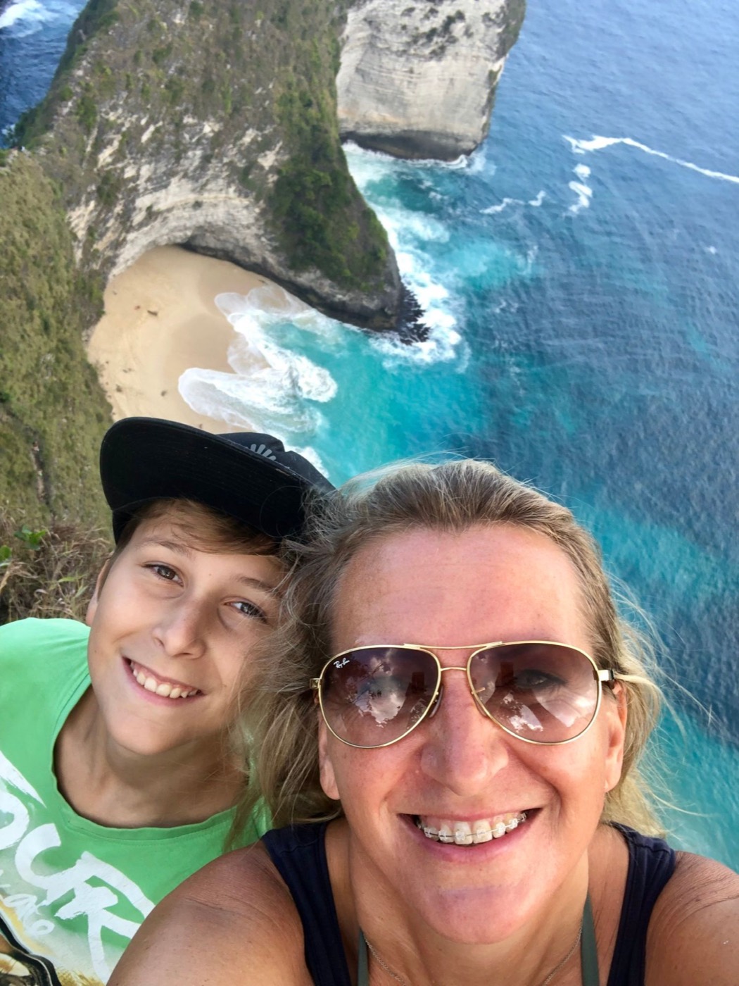 Selfie von Maria und Timo an der Steilküste auf Bali, unten türkises Meer